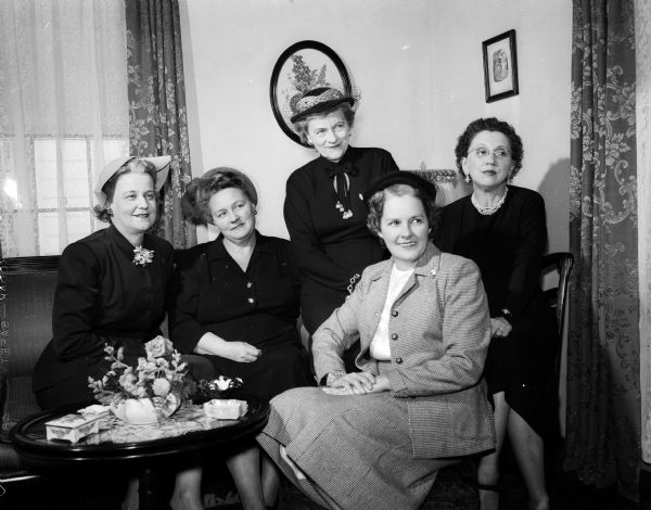 Group portrait of five members of the Pharmacist Wives group, in charge of planning a social event. Left to right: Mrs. Harold (Kathleen) Hall, vice-president; Mrs. Adolph (Minnie) Mallat, president; Mrs. William Lewis, decorations committee; Mrs. Emil (Alice) Hayden, secretary; and Mrs. Fred (Margaret) Simon, party chair.
