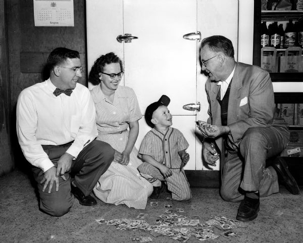 Four-year-old baseball enthusiast "Hoppy " Corcoran, center, enjoys a laugh with <i>Wisconsin State Journal</i> columnist Roundy Coughlin, right. Looking on, at left, are the boy's proud parents, Mr. and Mrs. Earl (Lucille) Corcoran.