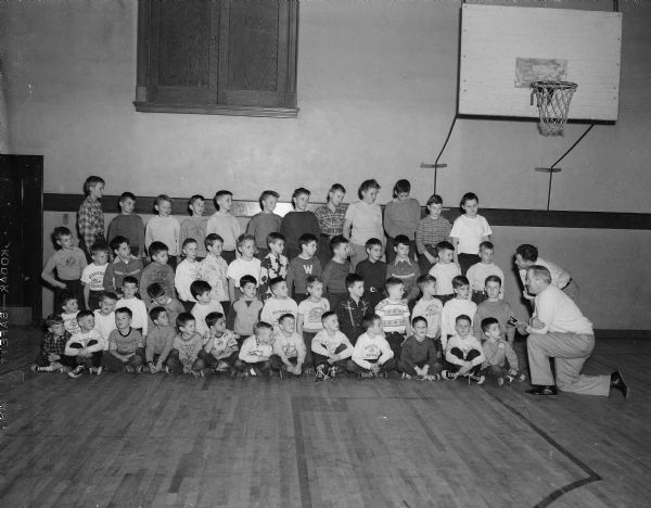 The seventeenth class of "Little Badgers" meet for their first training session with University of Wisconsin Boxing Coach Verne Woodward, at far right. The class is made up of boys aged six to fifteen from Madison and the surrounding area who learn the fundamentals of boxing.