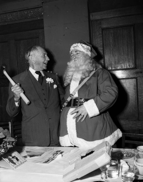 Louis Hirsig, celebrating his 75th birthday, stands with Santa Claus at a dinner for the employees of the Wolf, Kubly, and Hirsig Company at the Park Hotel.