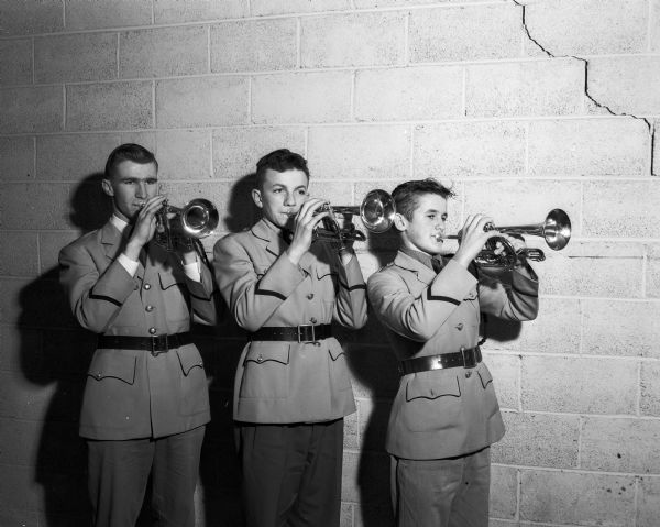 Portrait of a uniformed cornet trio featured in a concert of the Catholic All-City Band and the Edgewood High School band. Left to right are: Paul Haack, Michael Hayes, and James Shunk.