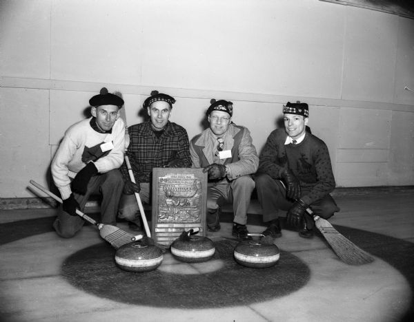 Group portrait of members of the Hugh Sinclair Rink from Milwaukee who won the fourth event finals of the seventh annual Midwest Curling Bonspiel with their trophy. From left, they are Hugh Sinclair, Robert Lorenz, George Morrison, and Bob Hower.