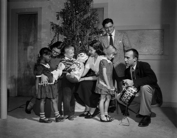 As one of the U.W. Student Service Projects, two men of the Mack House Dormitory and their dates host a Christmas party for children at the Volunteers of America Clubhouse. Students include, (from left): Joyce Clemans, Waukesha; Rosalile Pluim, Milwaukee; Rudy Cherkasky, Appleton: and James Barron, Beloit.