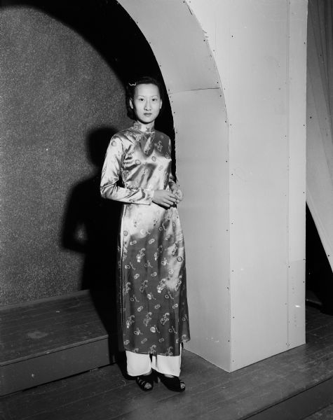 Vu Thi Yen stands in the doorway at Edgewood College while wearing a dress from her native country of Vietnam. She has come to the U.S. to study to become a teacher of teachers.