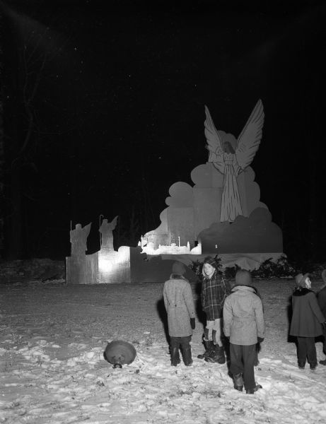 Four young residents of Maple Bluff stand in front of the giant 32-foot-high Christmas display of a manger scene at the intersection of Charing Cross Road and Laurel Lane in the village's Lynwood subdivision.