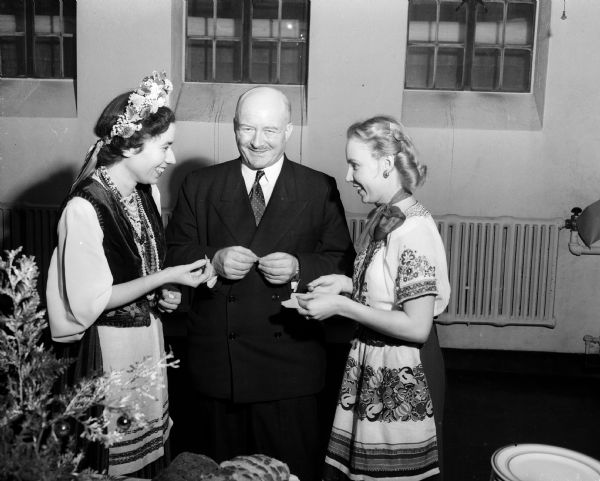 Polish statesman Stanislaw Mikolajcyzk, center, joins University of Wisconsin students studying Polish at the University of Wisconsin at a buffet supper. At left is Beatrice Pulikowski, Cincinnati, and at right is Helen Lunkiewicz, Milwaukee. The president of the International Peasant Union and the Polish National Democratic Committee was in Madison to give a lecture on post-war Poland.
