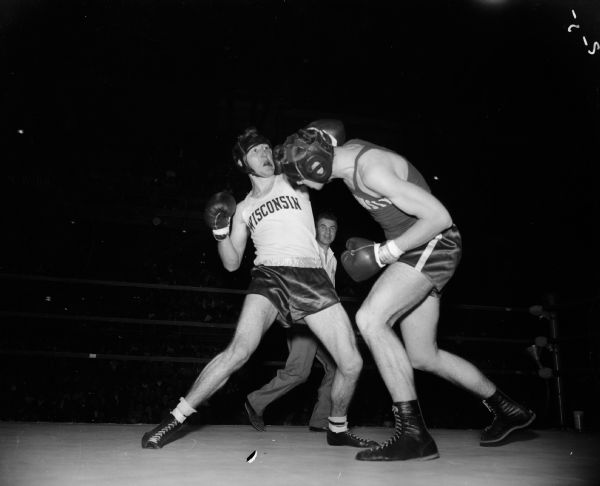 John Saxby of Oak Forest, Illinois, right, is shown throwing a right hand punch to Paul Emerson, Chippewa Falls, during the University of Wisconsin Boxing Tournament of Contenders.
