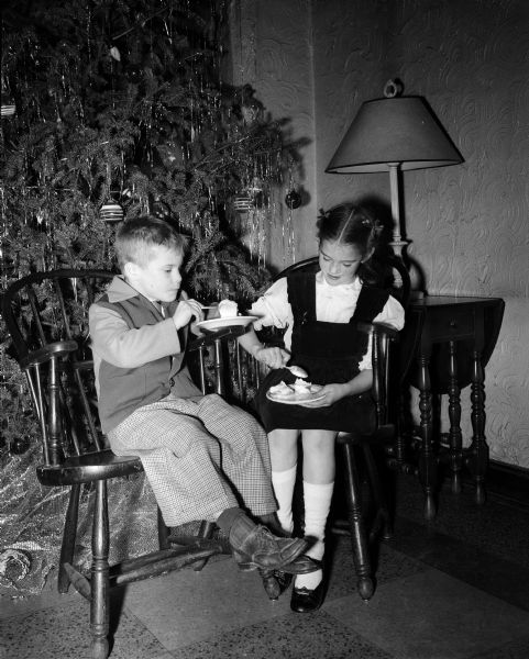 David Penn and Jane Darling, both seven years old, eat ice cream at the annual children's Christmas party for children and grandchildren of University Club members.