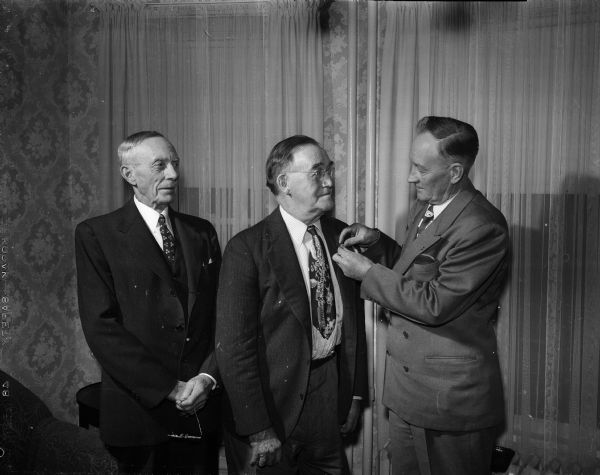 George Meyer, left and Gustave H. Sander, center, receive an award for 50 years of continuous membership in the AFL United Brotherhood of Carpenters and Joiners of America. Presenting the awards is Walter Jensen, right, President of the State Council of Carpenters.