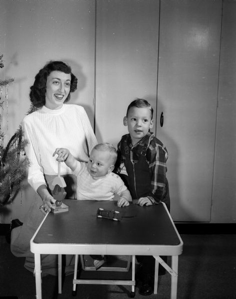 Polio victim Barbara Woroch cares for her two young sons, Gary, age 3, and Gregory, age 1. Barbara was stricken with polio three weeks before Gregory's birth and left with a paralyzed right arm. She underwent operations on the arm.
