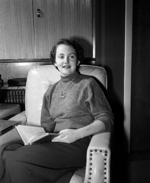 Ann E. Boberschmidt, Edgewood College sophomore, is shown wearing a necklace and sweater. She was stricken with polio in November of 1945, paralysing her left arm and right leg. Her arm was completely recovered and her leg partially recovered and she continued to take special therapy and exercises at the Orthopedic Hospital.