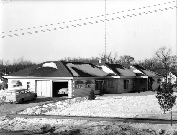 Exterior view of the ranch style house of Harold Baumgarten at 240 South Oak Street. Photograph is taken from the side showing the dwelling's two-car garage.
