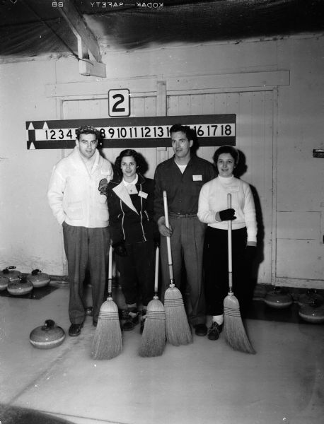 Mr. and Mrs. John Rogers and Mr. and Mrs. Frank Kimball, members of the John Rogers curling rink of Portage, posing at the second annual mixed bonspiel sponsored by the Portage Curling Club.