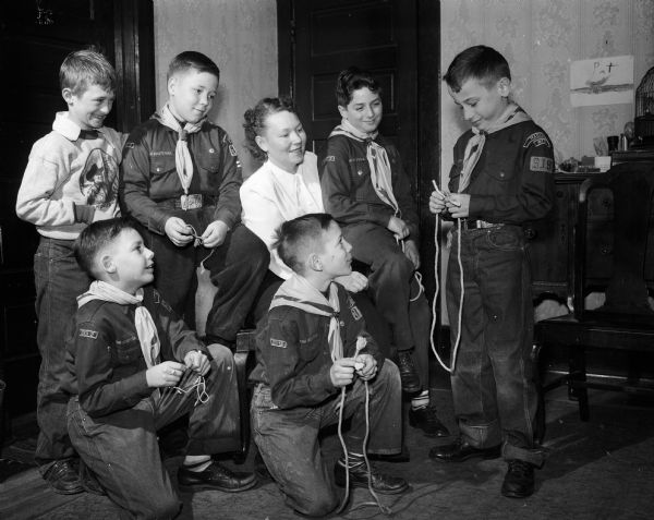 Cub Scout James Beckman, right, demonstrates tying knots to (from left): LaVern Wahlin, Bob Hilliard, John Streiff, and Billy Hoppe. Den mother Freda Hilliard is looking on.