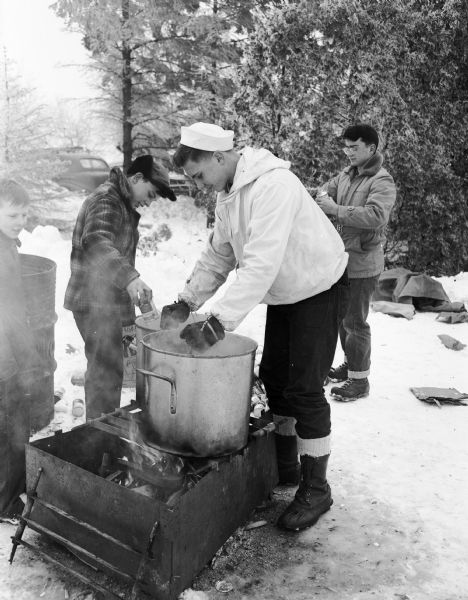 Three boy scouts prepare soup over a campfire during the Boy Scout Klondike Derby at Glenway Golf Course.