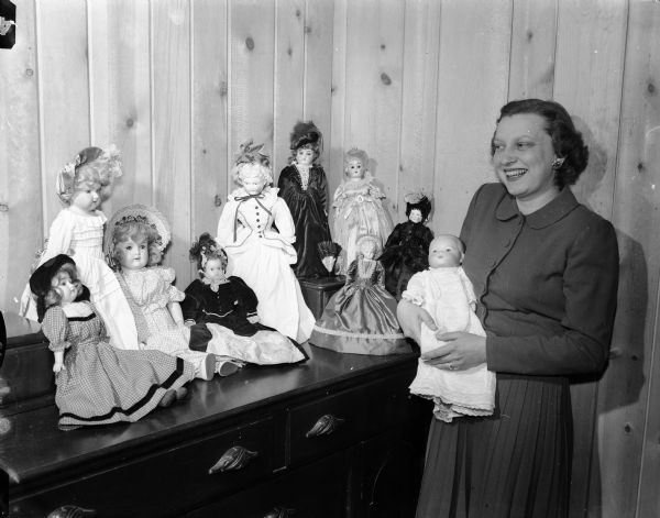 Mrs. Roman (Doris) Hilgers posing with some of her collection of dolls for which she has made fashion clothing over the past five years.