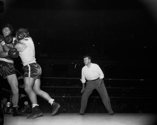 Paul Verwey of Racine pins University of Wisconsin boxer John Saxby against the ropes in their bout during a tournament at the University of Wisconsin-Madison Field House.