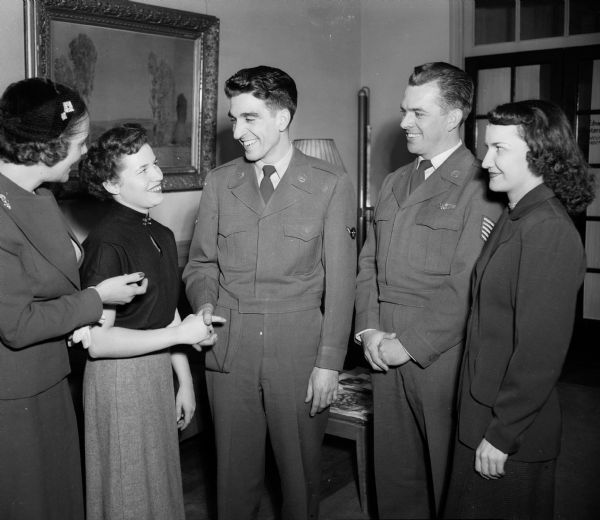 Organizers of a new YWCA-USO hostess unit discussing social events at Truax Field. Left to right are Mrs. Harris G. (Marion) Allen, senior hostess; Miss Doris Duerst, junior hostess; Pfc. Alfred Scapellati, New Britian, Connecticut; T. Sgt. Charles R. Olson, entertainment supervisor; and Miss Tina Fedele, a volunteer worker.
