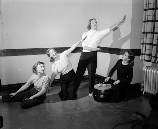 The junior division of the University of Wisconsin Service League for faculty wives has a number of interest groups including the modern dance group. Members of the group are pictured with their instructor, Mrs. James A. (Tana) Godfriaux, 405 North Baldwin Street, at right. Dance students left to right are Mrs. Paul (Marie) Eberman, 4130 Paunack Place; Mrs. Robert J. Francis, 5-B University Houses, president of the Junior division; and Mrs. D.E. Sergeman, 9-F University Houses.