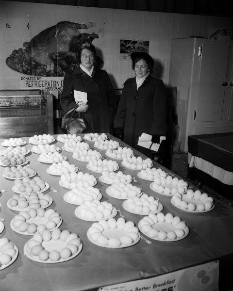 Eggs from all over the state are displayed at the stock pavilion on the University of Wisconsin campus during Farm and Home Week. Mrs. Leonard Husted (at left), and Mrs. LaVerne Johnson, both from Mt. Horeb, look over the display.
