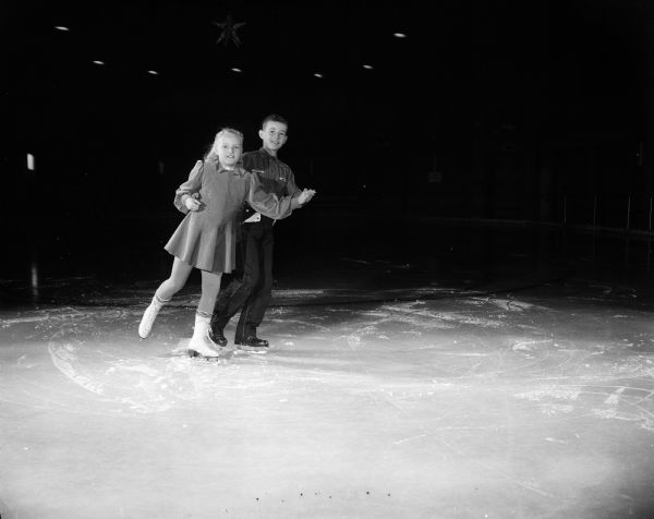 The junior skaters of the Madison Skating Club learn various figure skating maneuvers at the club's ice rink at Truax Field. Pictured are Tommy Doran, son of Mr. and Mrs. Thomas J. (Rosamond) ) Doran, 4117 Yuma Drive, and his partner, Karen Peterson, daughter of Sgt. and Mrs. Harry P. (Violet ) Gillingham, 212 Marion Street.