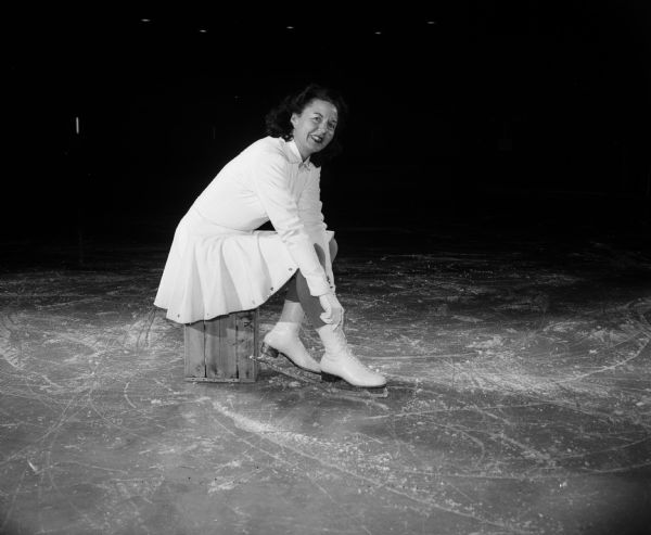 Leona Engelberger laces up her white skates; she is a member of the Madison Skating Club at Truax Field skating rink.
