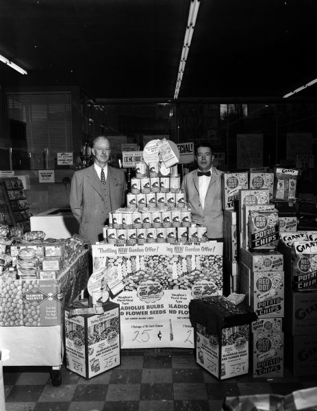 Two store employees of a Kroger store stand by an Old Dutch cleanser promotion for gladiolus bulbs in a store in Lancaster. Other merchandise displays including Red Dot Potato chips, flank the special promotion.