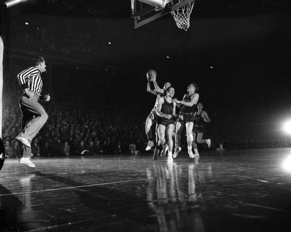 Action shot during the University of Wisconsin vs. Minnesota men's basketball game. Wisconsin player Tom Ward (51) is shown with the ball, preparing for a layup shot.