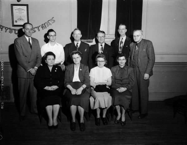 Group portrait of the officers of the Ray-O-Vac Battery Workers union. Left to right seated are: Evelyn Gotzion, Marion Shaw, Marcia Stich, and Maxine Boylen. Standing: Max Onsager, John Elliott, Henry Sweeney, W.C. Skaar, Ira Bailey, and Frank Learmonth.