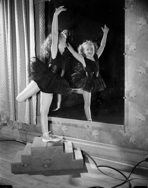 Portrait of Becky Winzeler, age 7, in a ballet pose in front of a mirror. She is a pupil of the Kathryn Hubbard Dance Studio.