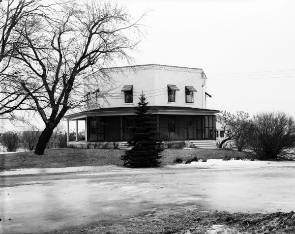 Exterior view of the residence and yard of Mr. and Mrs. Arthur J. Gafke, located in rural Fort Atkinson, Wisconsin. The octagonal house was built in 1850.