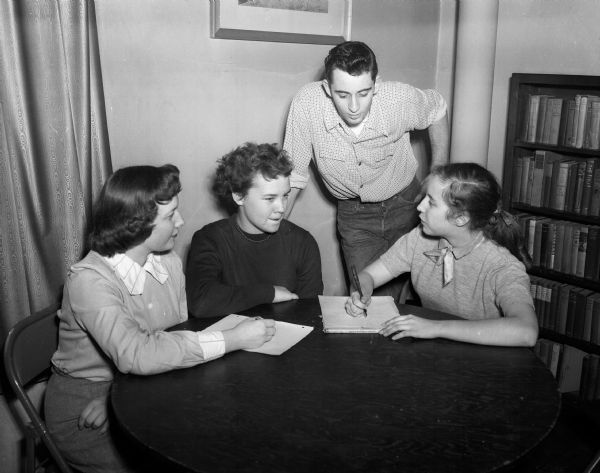 Four East High School students sitting at a table while planning a dance. They are, from left,  Carma Rae Chapman, Pattie McLeish, Ronald Lewis, and Arlene Barnett.