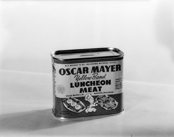 Studio photograph of a 12-ounce can of yellow band Oscar Mayer luncheon meat with a drawing of Little Oscar.
