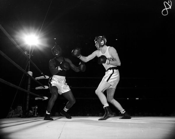 Bob Meath, Wisconsin, scores with a right hand punch to Penn State's Lazarus Lemon to win the boxing match in their class between the two universities in the University of Wisconsin-Madison Field House.