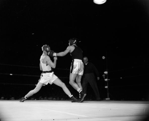 Ray Zale, Wisconsin, blocks a left jab by Penn State's Adam Kols in the 178-pound class in the final match of the boxing competition between the two universities. Wisconsin defeated Penn State 5 1/2 to 2 1/2.