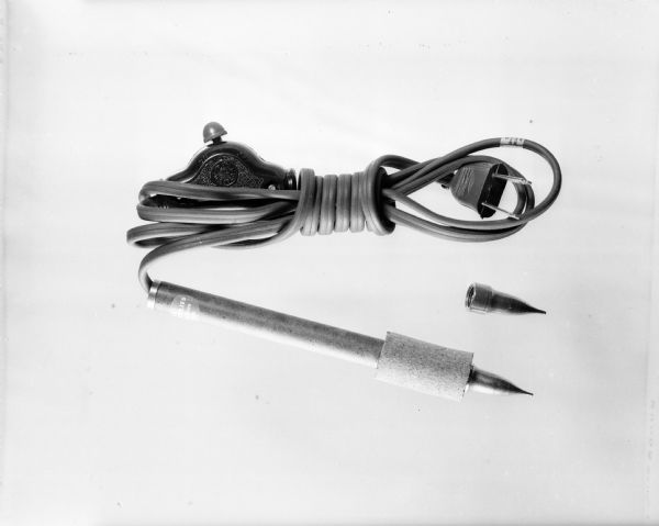 One of a series of photographs depicting Demco Office Supply Company products; they include a book repair kit, paste jar, 2 brushes, and a heat gun.