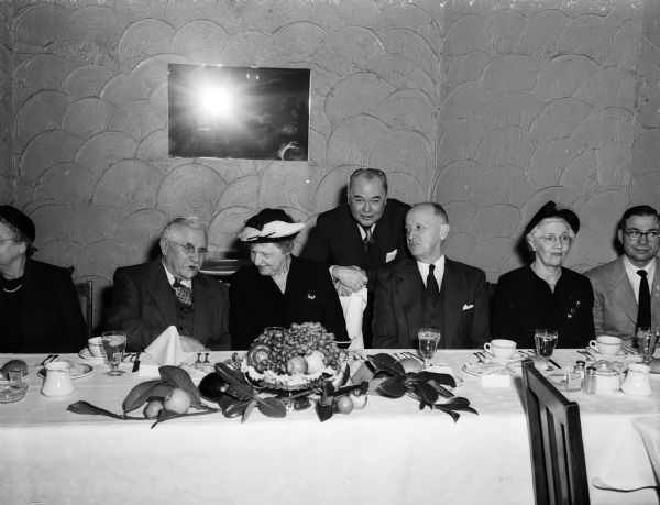 Group portrait of seven people at the head table during a testimonial dinner honoring Dr. William D. Frost, retired president of Morningside Tuberculosis Sanitorium. Dr. Frost is seated second from the left. To his right are Mrs. E.B. (Rosa) Fred, representing UW; Laurence W. Hall, representing Morningside; and William S. Middleton, dean of UW medical school.