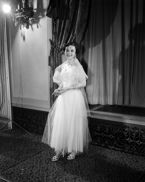Mrs. Lee (Alma) Baron of 3304 Blackhawk Drive modeling a ballerina-length gown for the Jaycettes style show at the Hotel Loraine, 123 West Washington Avenue.