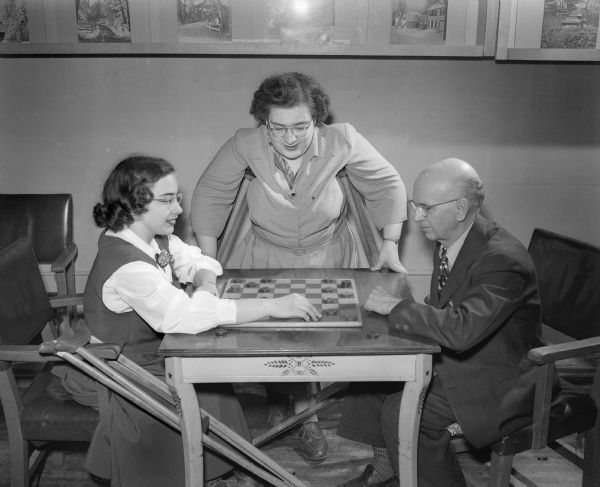 Enjoying a game of checkers at the Madison Community center are three members of the Happy Hour club, a social organization for handicapped adults. From left to right, the trio includes: Deloris Tenjum; president of the club; Mary Ann O'Loughlen; and Elmer Fergot. Members of the club are transported to club meetings by taxis, the funds for which are provided by the sale of Easter Seals.