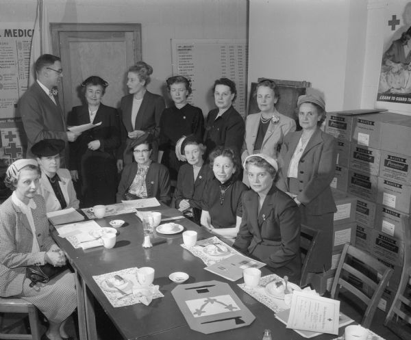 Twelve members of the first class of social welfare aids to the Red Cross home service are shown with their class certificates and pins authorizing them to serve as Red Cross volunteers.