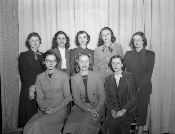Group portrait of a Panhellenic Council (representatives of U.W. professional sororities) committee.  Front row, left to right: Rita Holzer, Lancaster; Jeanne O'Donnell, Madison; and Peg Kyle, Milwaukee.  Back row: Karen Spaulding, Waupun; Catherine Vakos, Racine; Myra Handlovsky, Superior; Ann Louise Resh, Madison; and Colette Trouard, Madison.