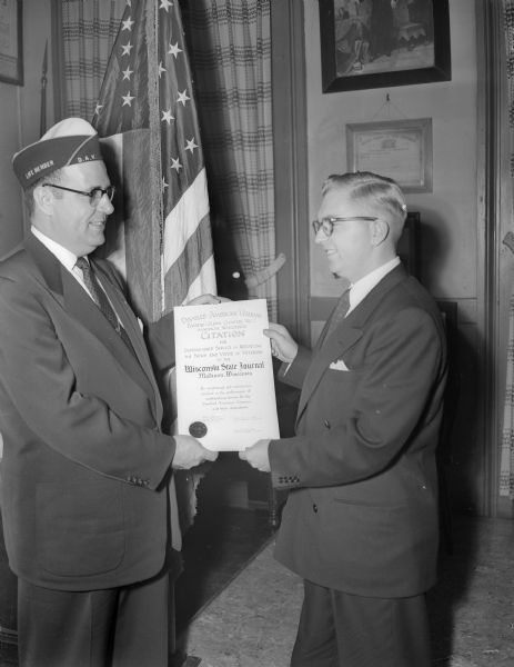 The <i>Wisconsin State Journal</i> was awarded a citation for its "distinguished service in reporting the news of veterans" by the Madison DAV chapter. Herbert P. Velser (left) West Allis, national third junior vice-commander, made the presentation to Robert C. Bjorklund, the reporter who accepted the citation on behalf of the newspaper.