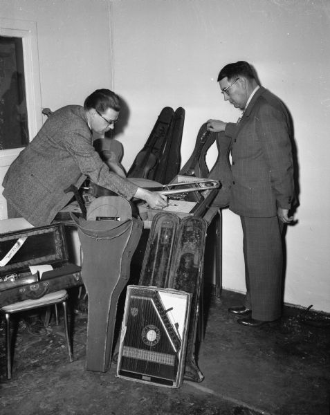 G.I. Wallace and Clarence Graham looking over some of the discarded musical instruments donated to the state-wide project collecting musical instruments for the five state mental institutions.