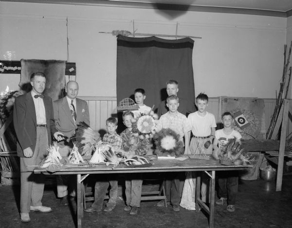 Two men and seven boys with Indian artifacts (YMCA).