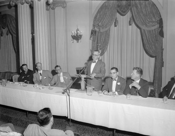 Seven men at the head table at a Oscar Mayer Dinner.