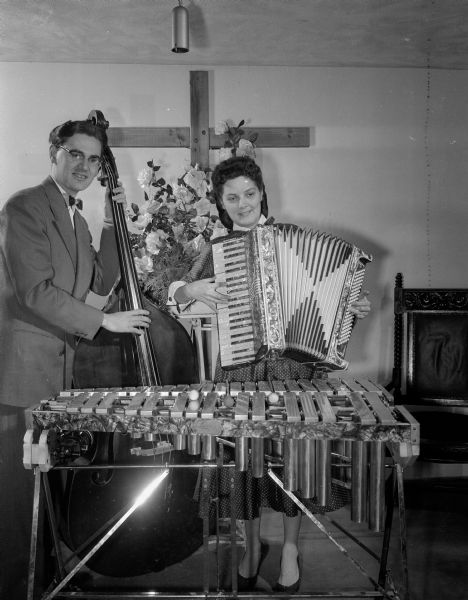 Two musicians (Hendericks ? and Floy ?) with their instruments, accordion, xylophone, and base fiddle.  Appears to be a church setting.