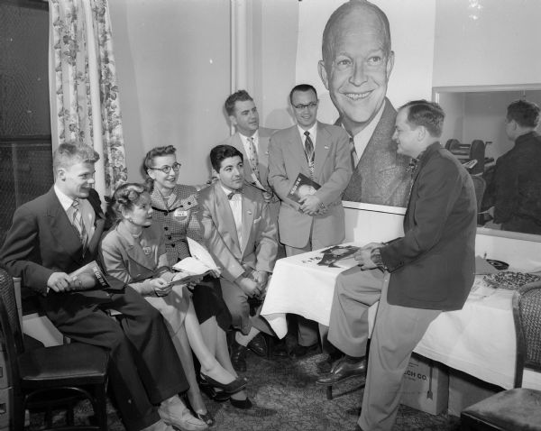 Young republicans for Eisenhower meet officers of the Madison headquarters of Wisconsin Citizens for Eisenhower Committee at the Loraine Hotel.  L. to R: John Williston, Milwaukee; Mary Lou VanRoo, Madison, headquarters administrative assistant; Mrs. Lorrie Bettencourt, Milwaukee; Kenneth Hurwitz, Sumpter; Roland Viegh, Madison, headquarters organization director; Fred R. Draeger, Madison, information director and James Menn, State chairman of Young Republicans for Eisenhower.