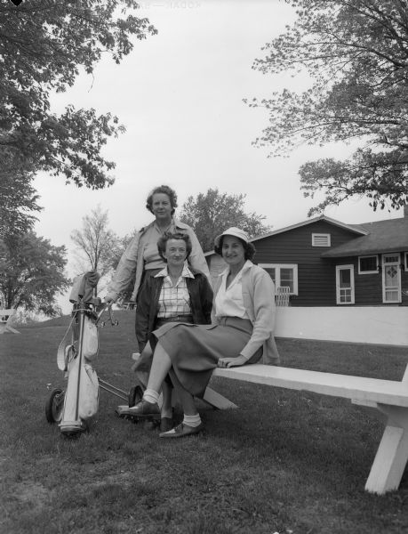 Three members of the Blackhawk Coutry Club's golf committee near the clubhouse.  Left to right:  Esther Bixby, handicap chairman; Beatrice Cartwright, assistant golf chairman, and Charline Larson, in charge of golf tournaments.