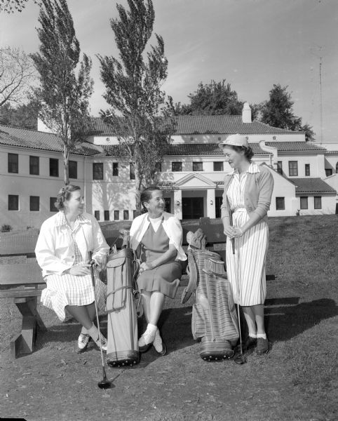 Three chairmen of the Maple Bluff Country Club women's organization in front of the clubhouse.  Left to right, Mariel Campbell, Geneva Johnson and Florence Lunger.