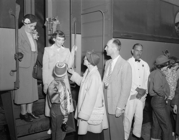 <i>Wisconsin State Journal's</i> 1952 spelling champion, Beth Knope, boards a train to attend the national finals. Saying goodbye are her parents Sidney and Pearl Knope, and her brother Dave. Her teacher, Floy Kendrick, stands by Beth on the train steps.